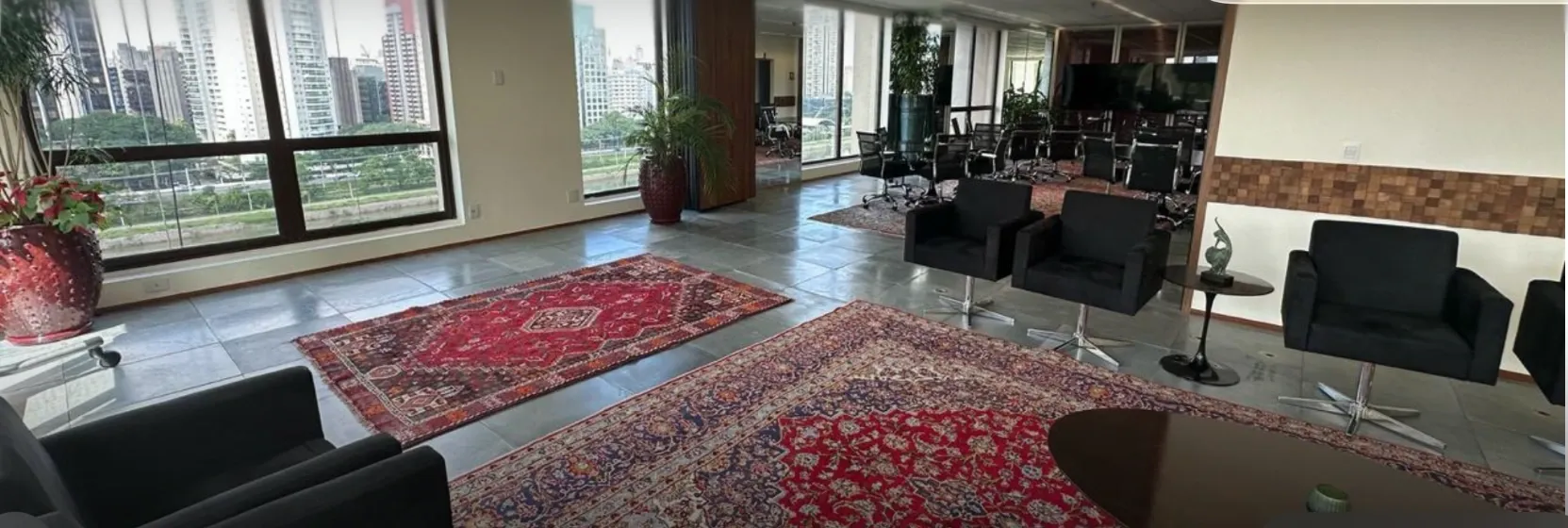 Ambiente corporativo amplo com luz natural e acabamento sofisticado